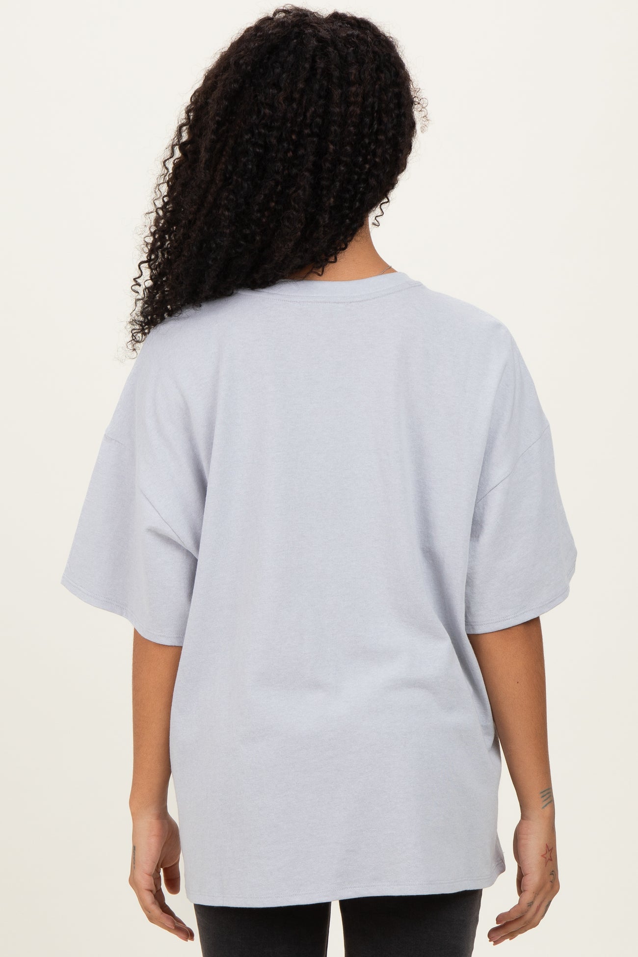 woman wearing a light gray oversized t-shirt seen from the back