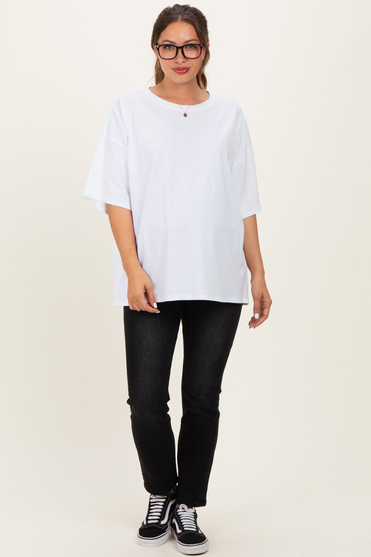 woman wearing a white oversized maternity t-shirt with a round neckline paired with black jeans