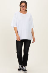 woman wearing a white oversized maternity t-shirt with a round neckline paired with black jeans