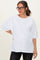 woman wearing a white oversized maternity t-shirt with short sleeves and a relaxed fit, paired with black jeans
