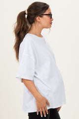 woman wearing a white oversized maternity t-shirt with a visible baby bump and sunglasses