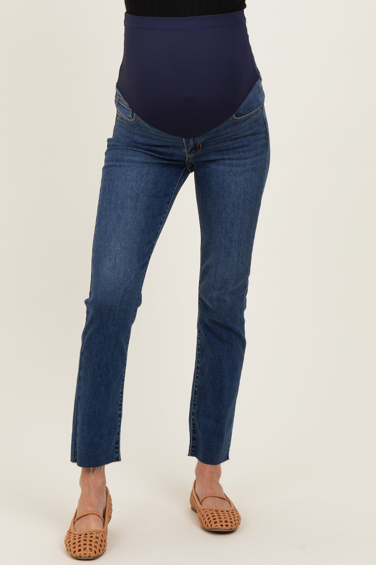 woman wearing blue maternity jeans with a supportive belly band and frayed hem details