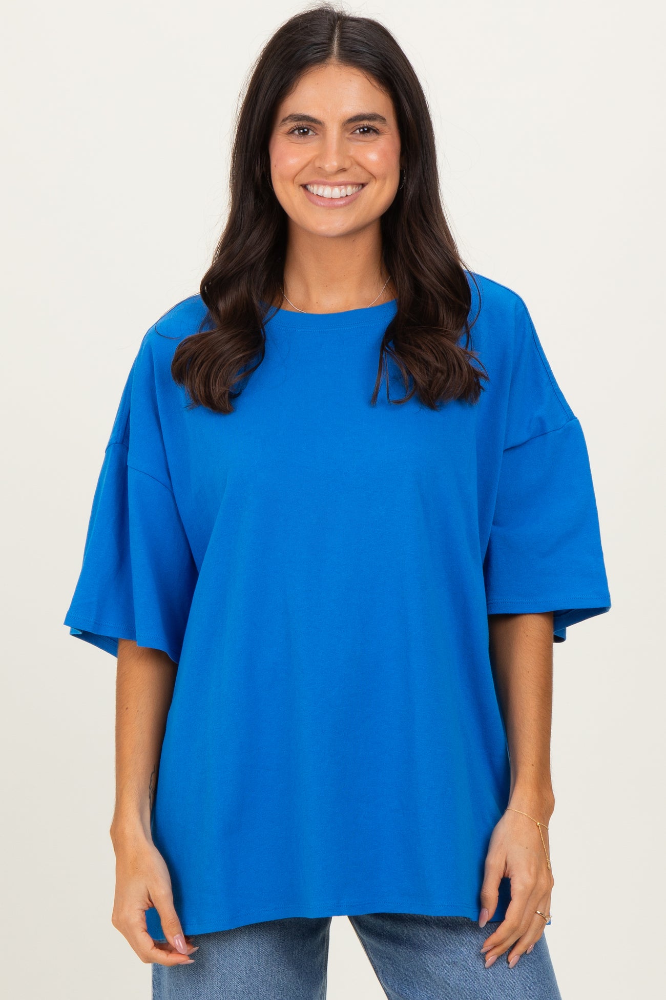 woman wearing a bright blue oversized t-shirt with wide sleeves and a relaxed fit