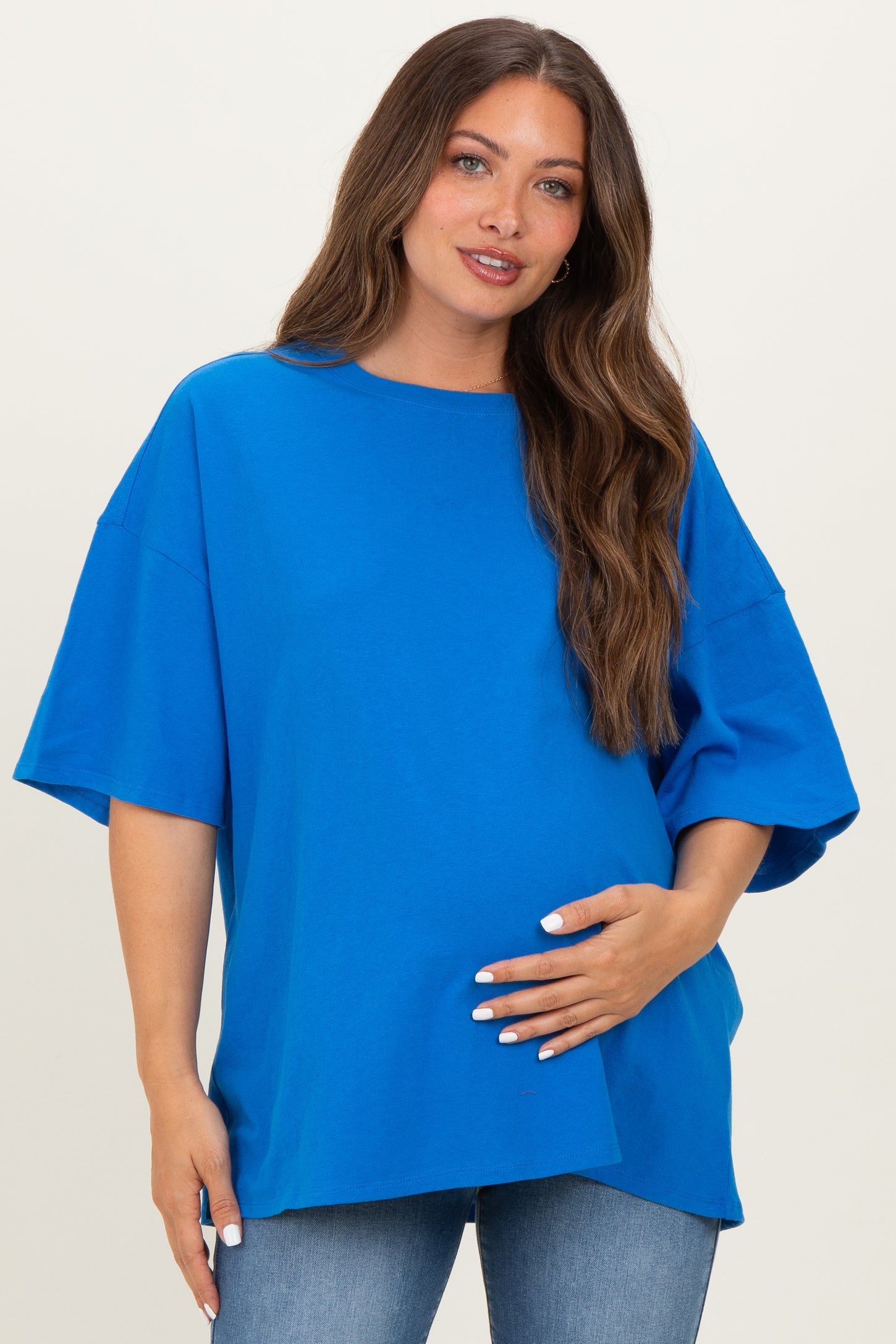 woman wearing a bright blue oversized maternity t-shirt and holding her baby bump
