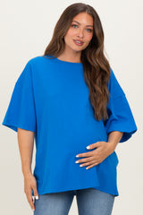 woman wearing a bright blue oversized maternity t-shirt and holding her baby bump