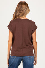 woman wearing a brown short sleeve maternity top, viewed from the back, paired with blue jeans