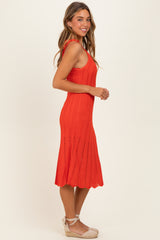 woman wearing a vibrant red knitted midi dress with a flared hem and adjustable straps