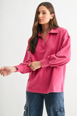 woman wearing a pink long sleeve polo-style top with a relaxed fit and soft fabric, paired with denim cargo pants