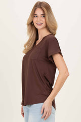 woman wearing a brown short sleeve v-neck t-shirt with a chest pocket and smiling