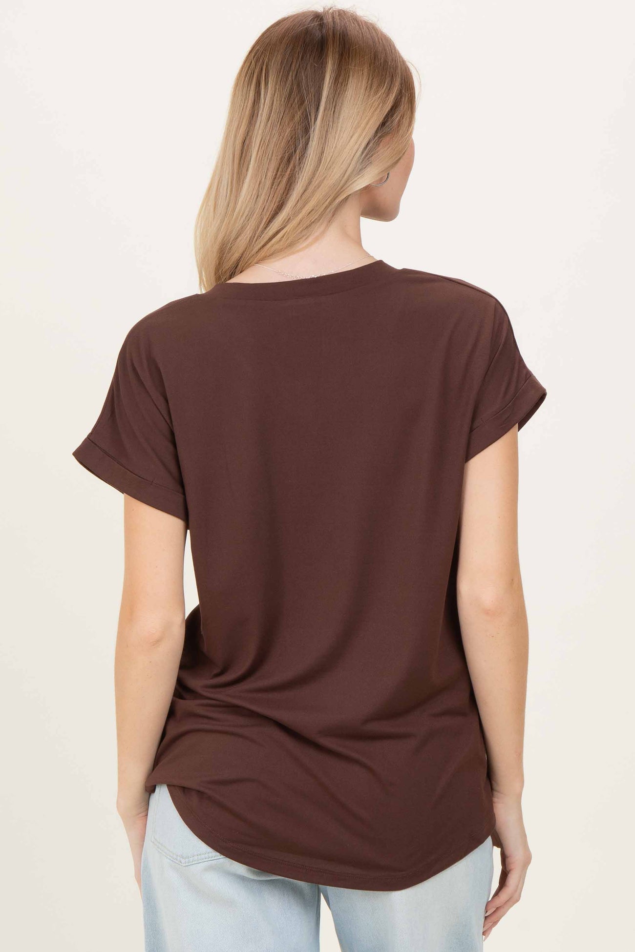 woman wearing a brown short sleeve top, viewed from the back, paired with light blue jeans