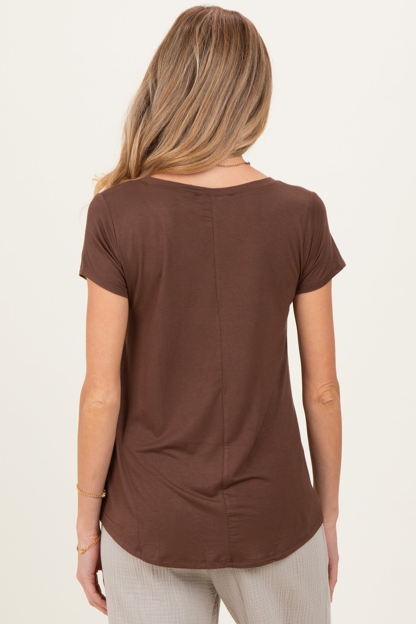 woman wearing a brown short sleeve maternity top, shown from the back