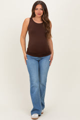 woman wearing a brown maternity tank top and blue flared jeans, showing her baby bump