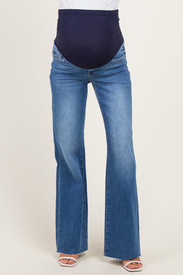 woman wearing a pair of blue maternity flared jeans with a dark navy belly band