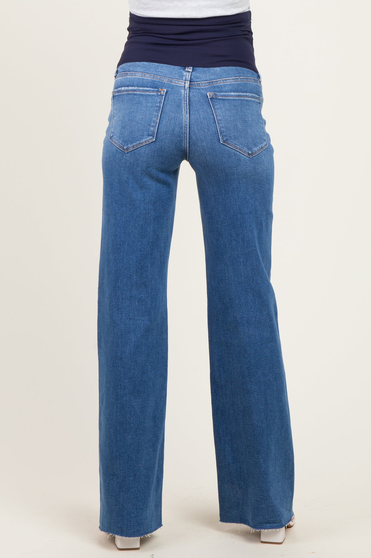 woman wearing blue maternity jeans with a comfortable waistband, showing the back view