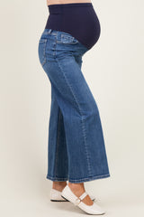 maternity wear high-waisted flare jeans in dark blue, featuring a supportive waistband and a visible baby bump.