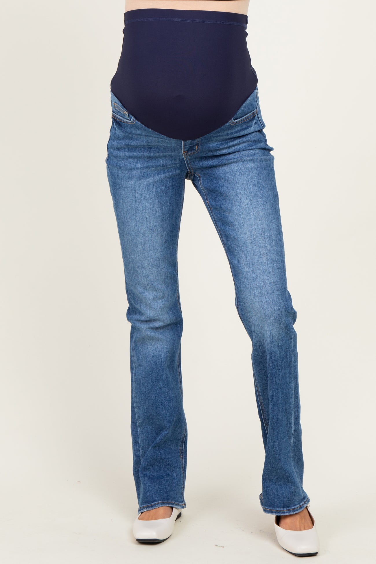 woman wearing dark blue maternity jeans with a stretchy waistband, showcasing a visible baby bump