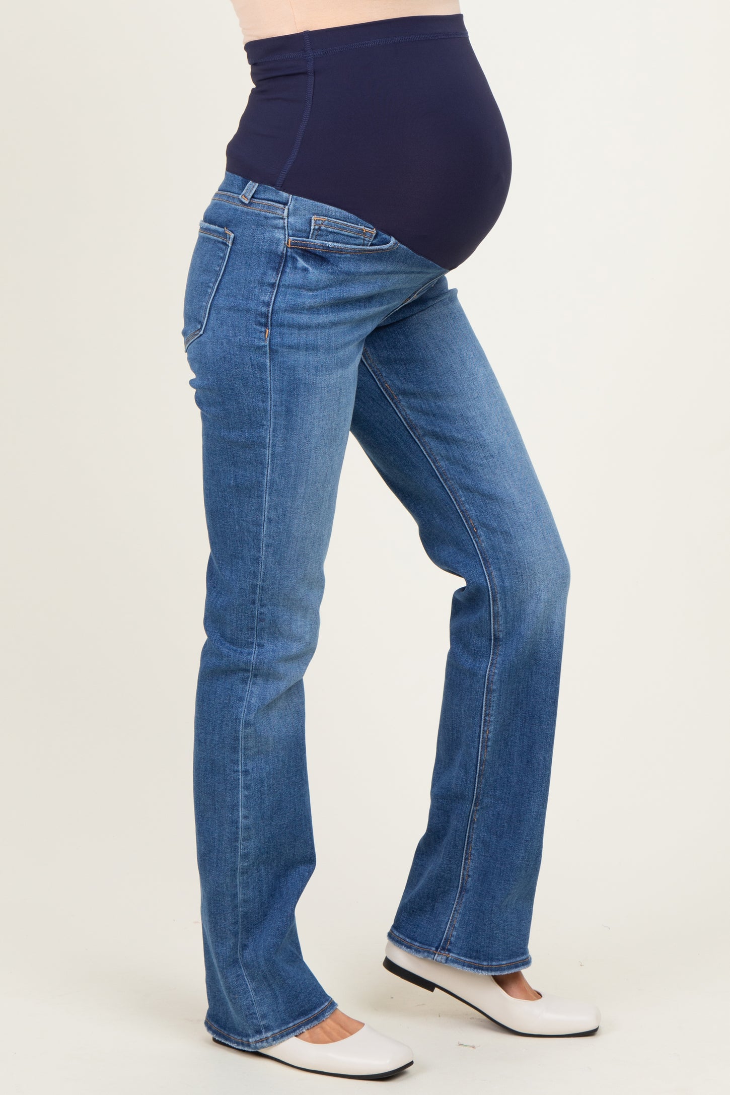 woman wearing dark blue maternity jeans with a supportive waistband and a visible baby bump