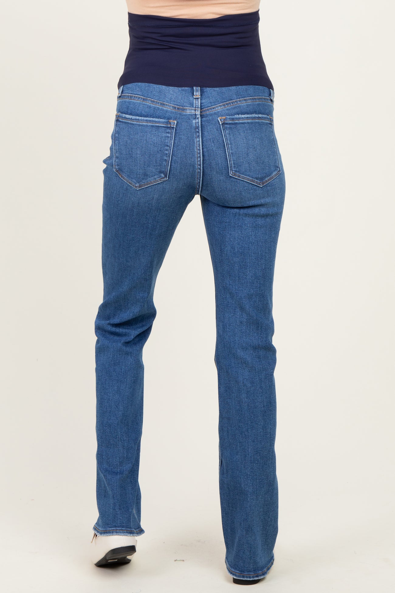 woman wearing blue maternity jeans, viewed from the back, showcasing a stretchy waistband