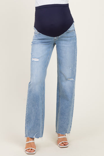 woman wearing light blue distressed maternity jeans with a dark blue over-the-bump waistband