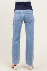 woman wearing light blue maternity jeans with a dark blue over-the-bump waistband, showing a relaxed fit and frayed hem