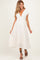 woman wearing a white maternity dress with short sleeves and black polka dots, featuring a v-neckline and flowing skirt