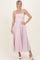woman wearing a light pink spaghetti strap midi dress with a fitted bodice and flowy skirt