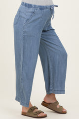 woman wearing light blue maternity pants with elastic waistband and side pockets, showcasing her baby bump