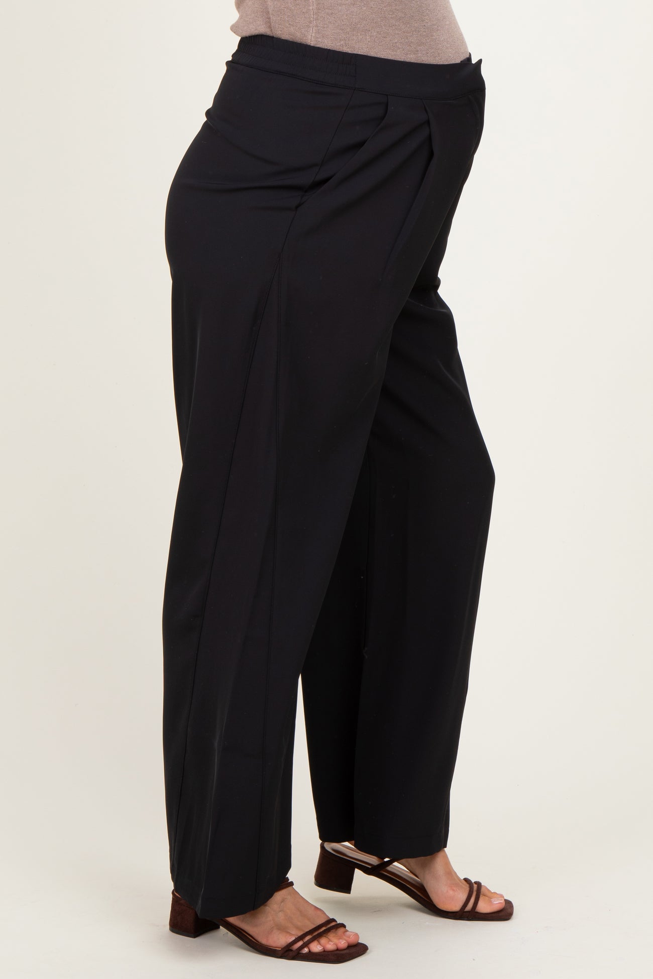 woman wearing black maternity trousers with a pleated front and a visible baby bump