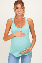 woman wearing a light teal maternity tank top and holding her baby bump