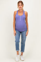 woman wearing a purple maternity tank top with buttons and blue rolled cuff jeans, showcasing her baby bump