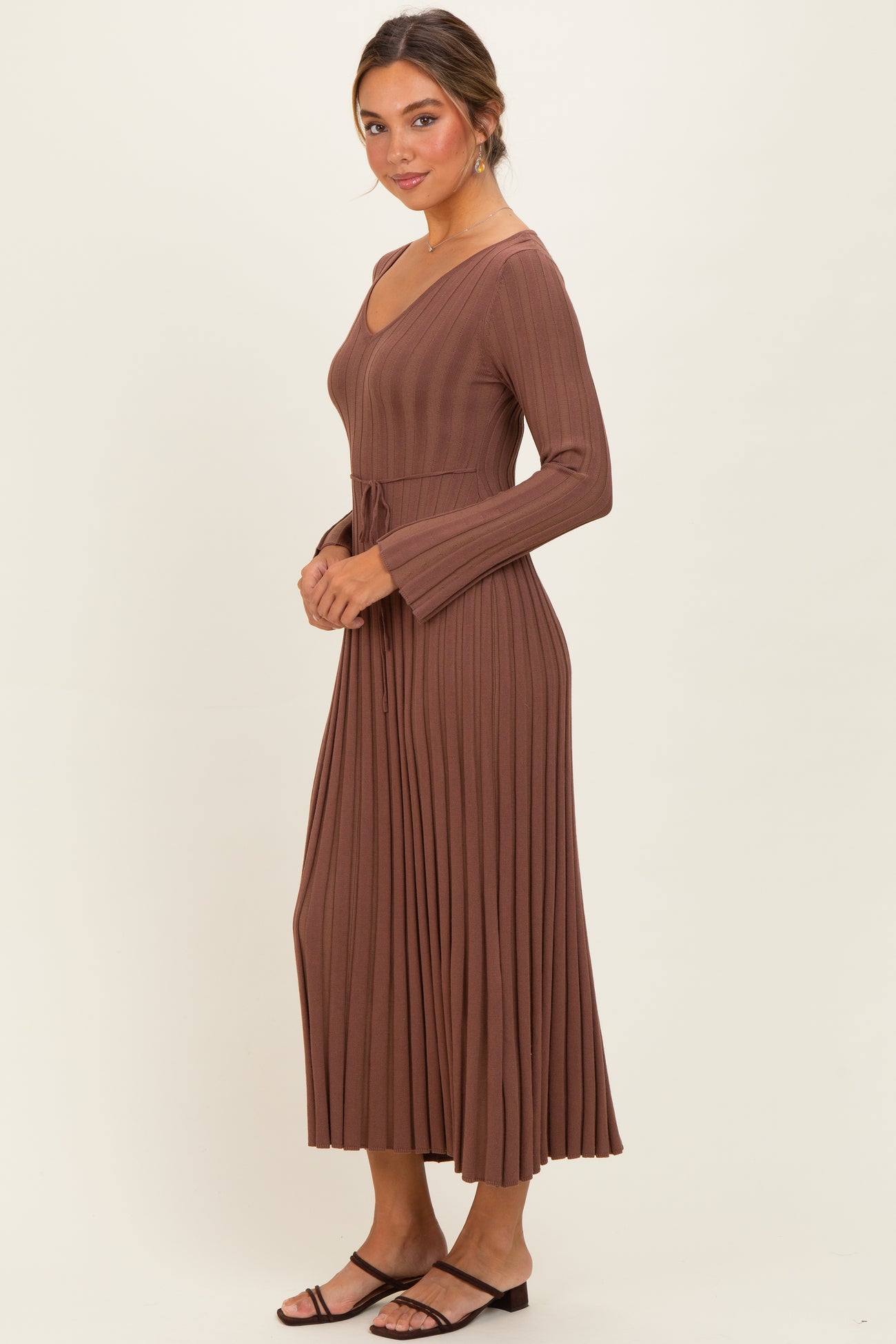 woman wearing a brown ribbed long sleeve maxi dress with a tie waist and flared sleeves