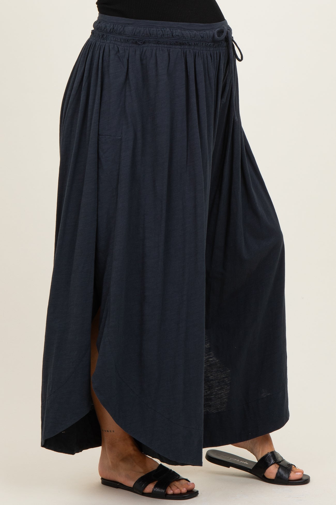 woman wearing a navy blue maternity maxi skirt with a high-low hem and elastic waistband