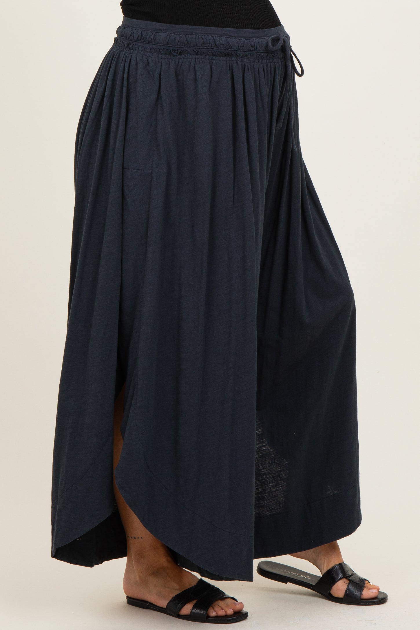 woman wearing a navy blue maternity maxi skirt with a high-low hem and elastic waistband