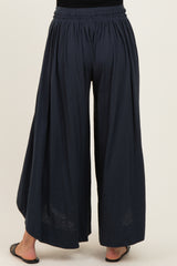 woman wearing navy blue wide-leg maternity pants with an elastic waistband and flowing fabric from the back
