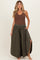 woman wearing a brown ribbed maternity tank top and olive green wide-leg maternity pants with side slits