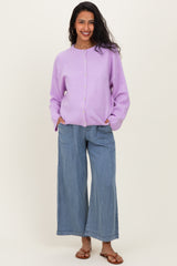 woman wearing a lilac maternity cardigan with buttons and relaxed blue wide-leg jeans