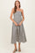 woman wearing a black and white striped strapless maternity maxi dress and holding her baby bump