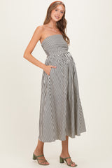woman wearing a striped strapless maternity dress with pockets and a visible baby bump