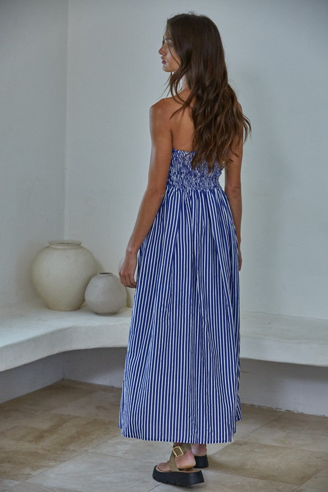 woman wearing a blue and white striped maxi dress with a smocked back, styled with long wavy hair