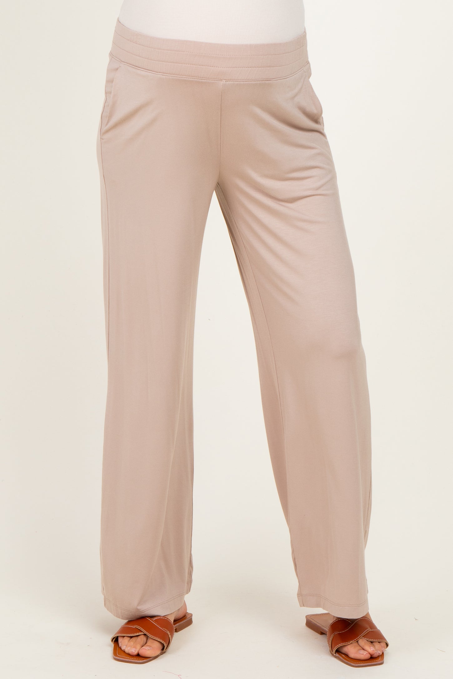 woman wearing beige maternity pants with a comfortable waistband and loose fit