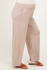 woman wearing light beige maternity pants with side pockets and a visible baby bump