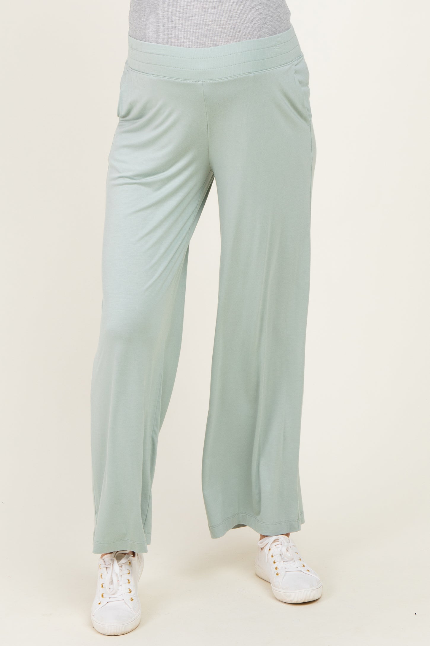 woman wearing light green maternity wide-leg pants with a relaxed fit and side pockets