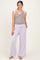 woman wearing a gray tank top and lavender maternity pants with pockets, showcasing her baby bump