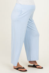 woman wearing light blue maternity pants with side pockets and a comfortable waistband, showcasing a visible baby bump