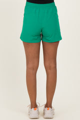 woman wearing green maternity shorts, shown from the back