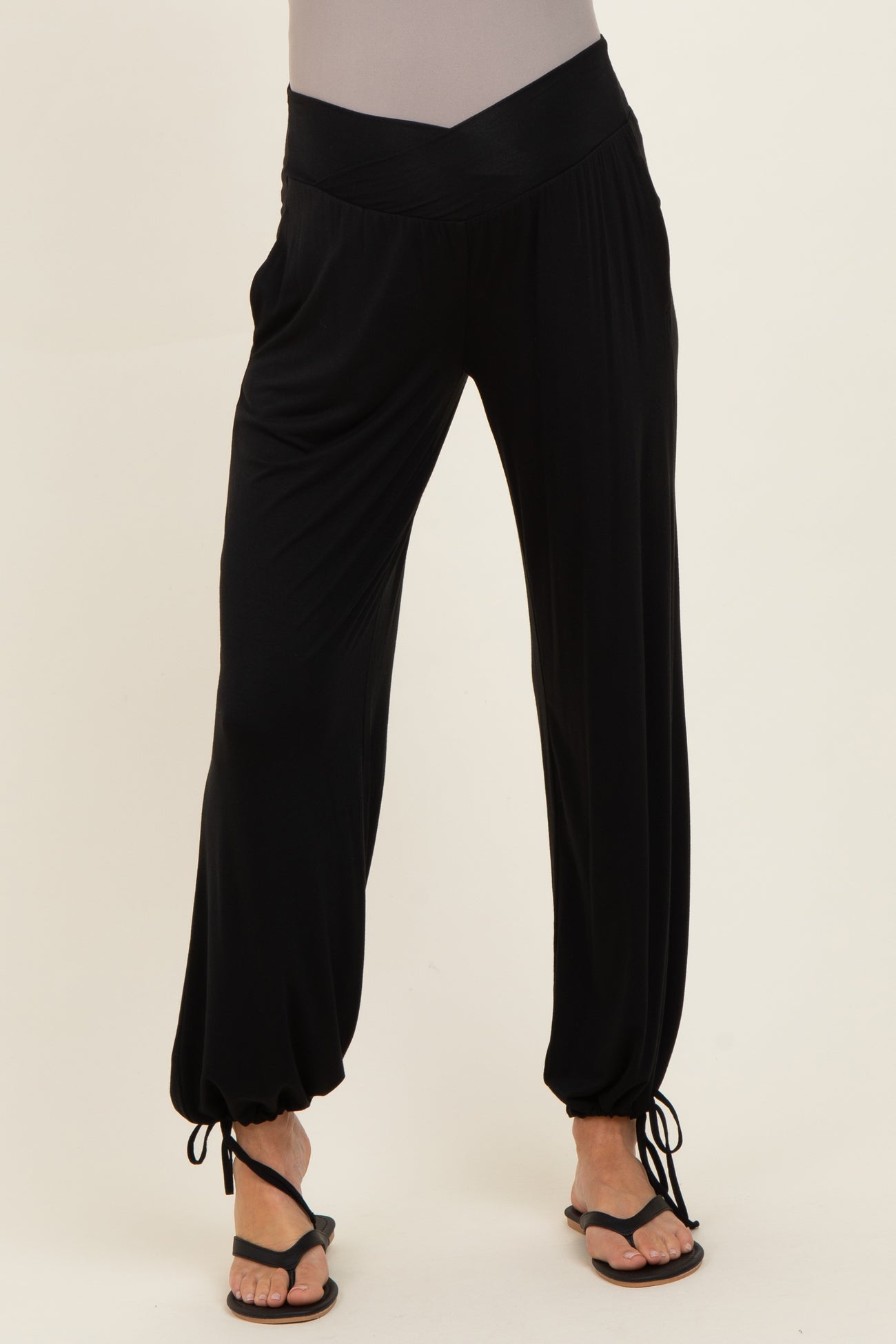 woman wearing black maternity harem pants with a wide waistband and ankle ties