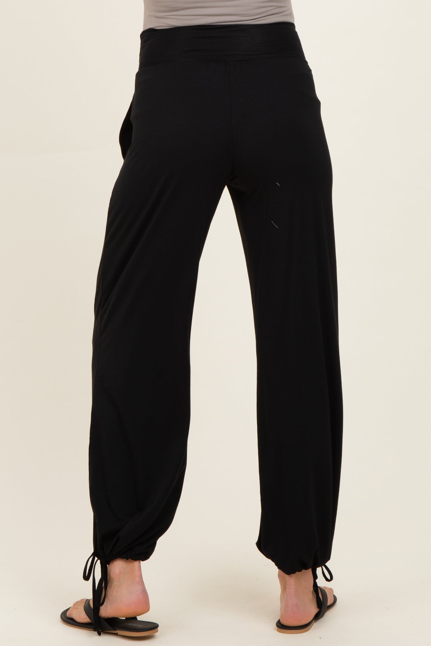 woman wearing black maternity pants with adjustable ankle ties, viewed from the back