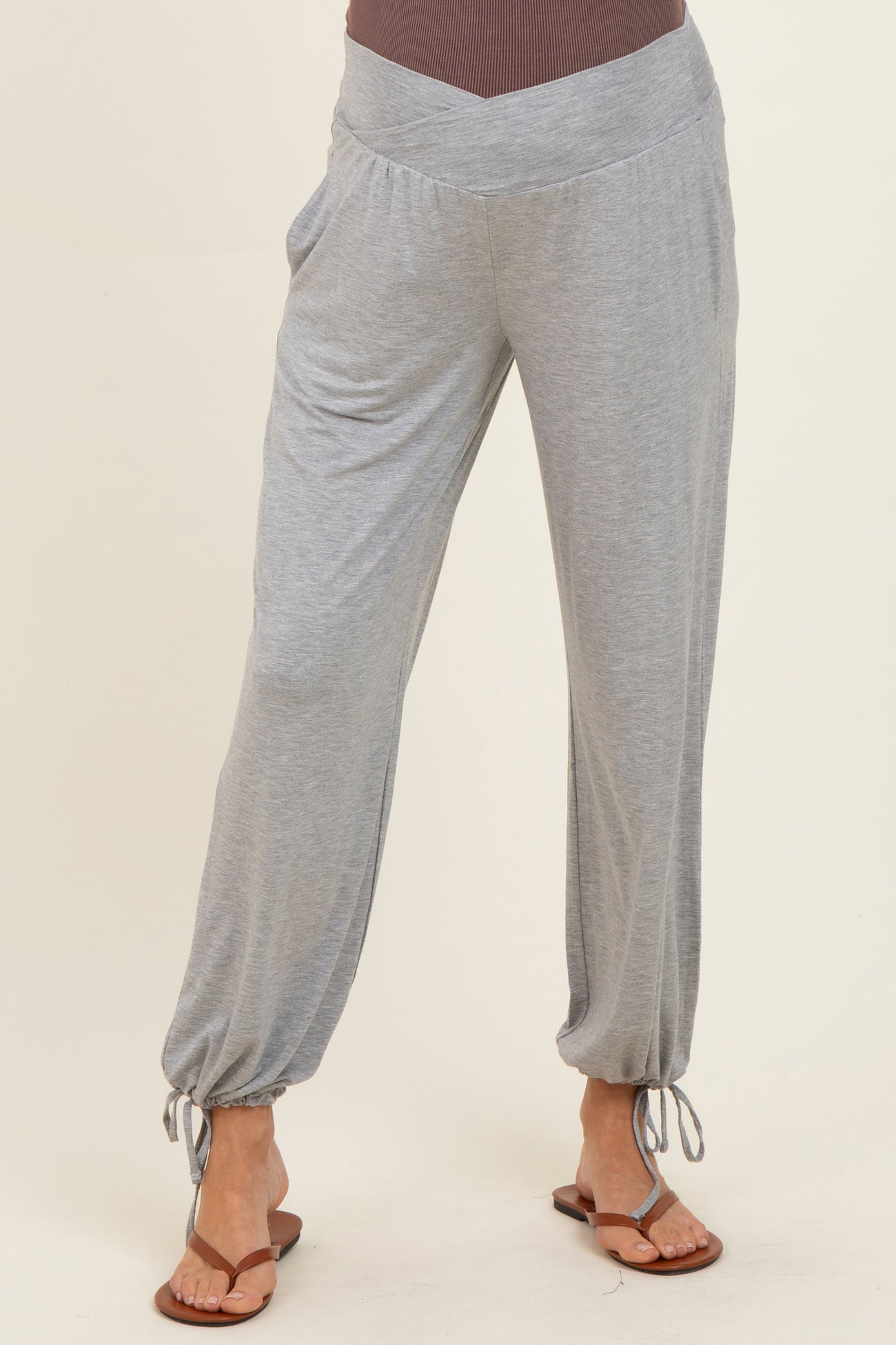 woman wearing light grey maternity lounge pants with a drawstring cuff detail