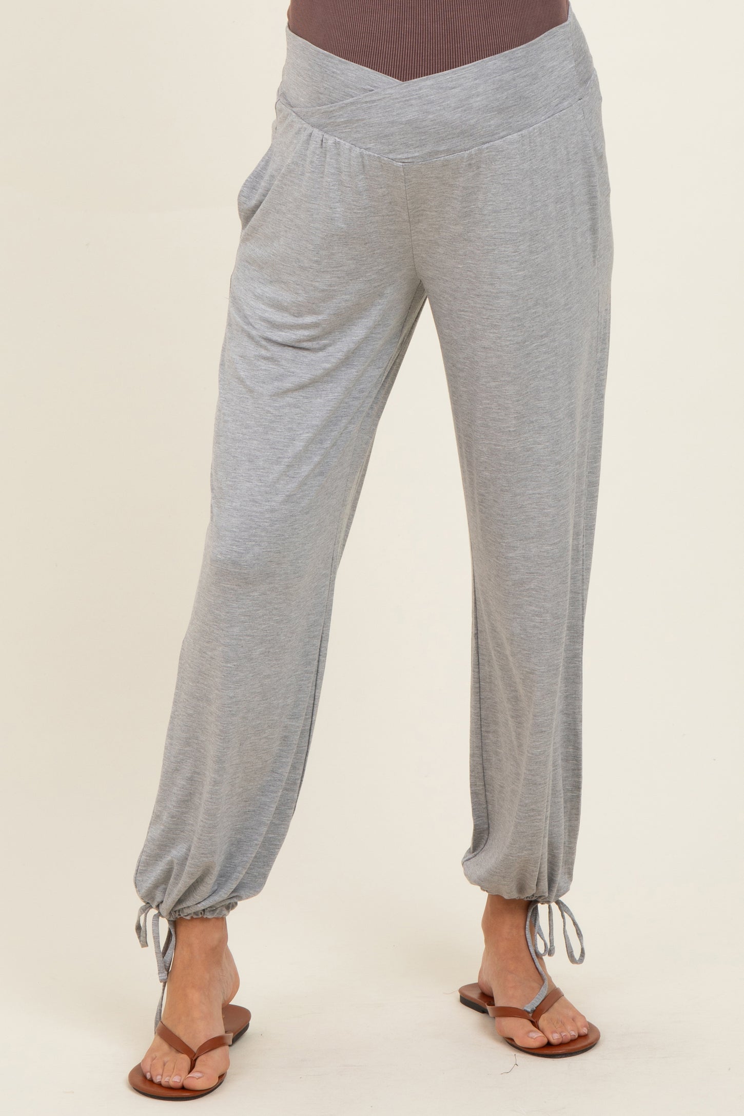 woman wearing light grey maternity lounge pants with a drawstring cuff detail