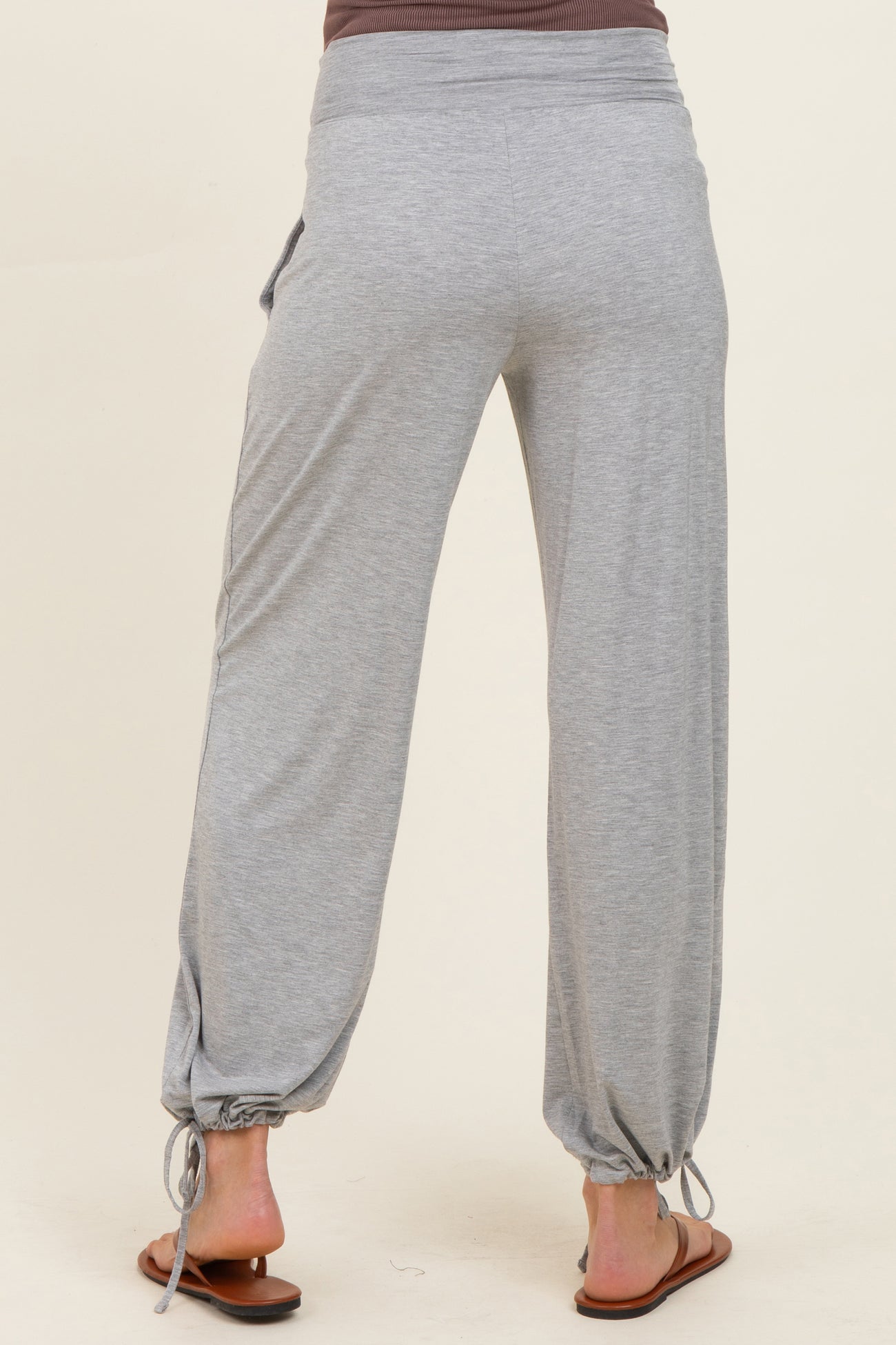 woman wearing gray maternity jogger pants with adjustable ties at the ankles, showing a relaxed fit and soft fabric